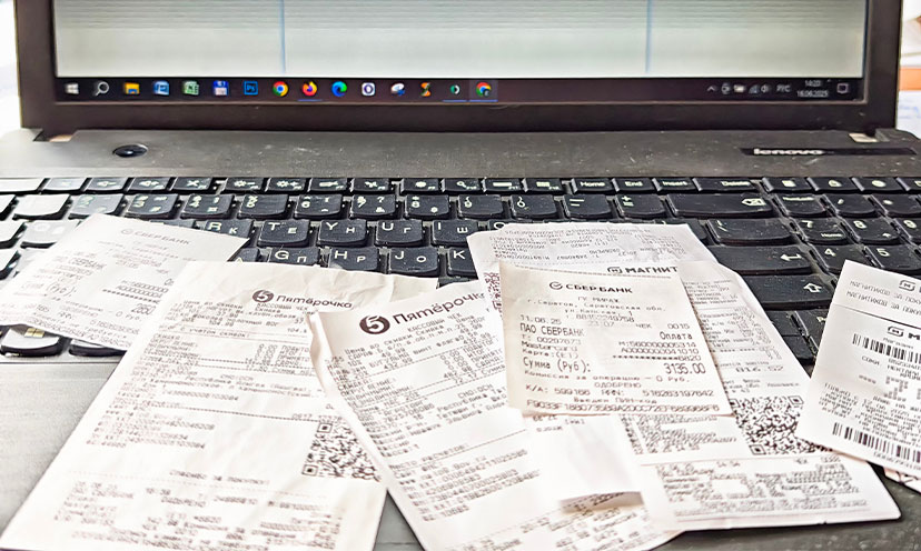 Receipts piled on a laptop keyboard